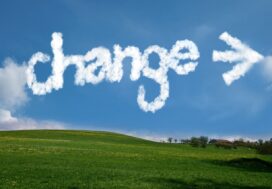 The word 'change' and an arrow formed by clouds in a bright blue sky over a rolling green landscape, symbolizing the transition process in legal software implementation